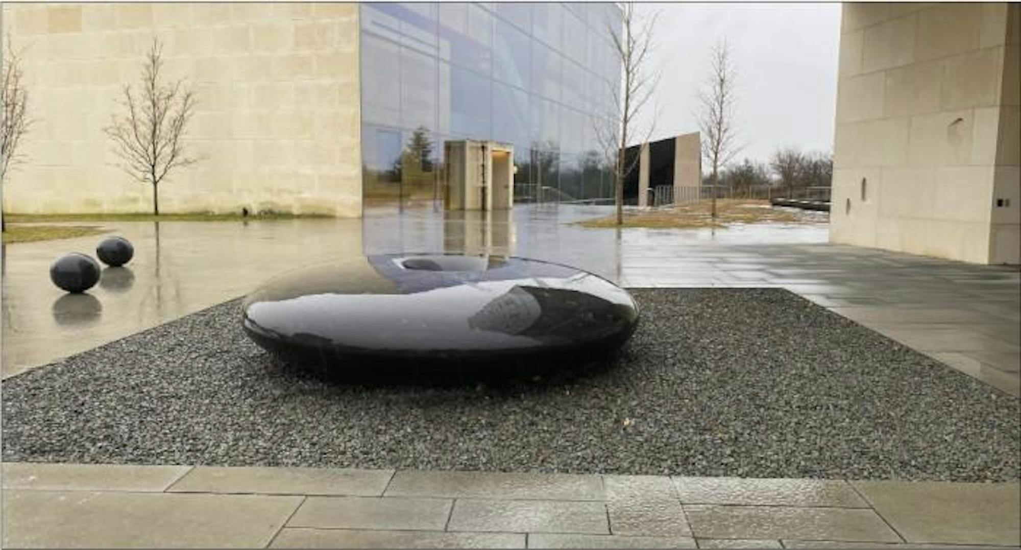 Photograph of Lin's "Einstein's Table," a black water table covered in running water, placed outside of the Lewis Center for the Arts 