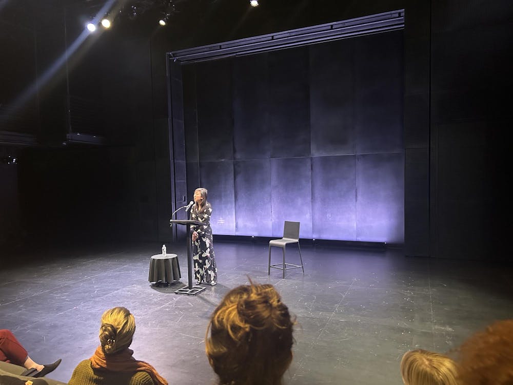 A woman standing at a podium in a theater.