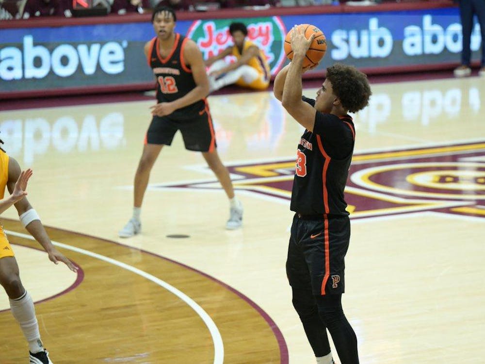 A player in a black jersey jumping and shooting a basketball.