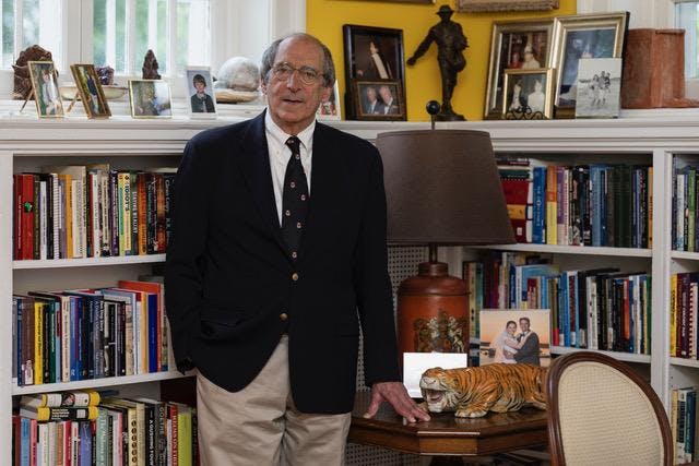 A man standing in front of a bookshelf.