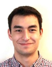 A profile of a man with brown hair and brown eyes smiling.