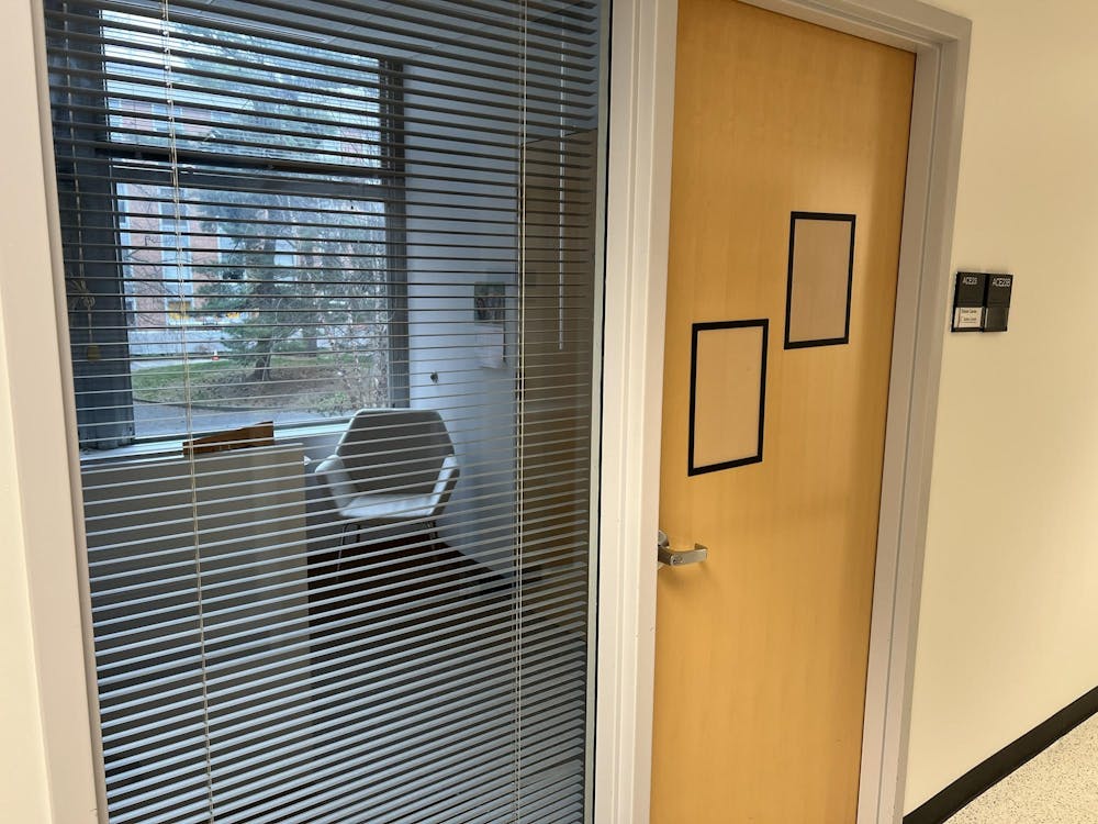 An empty office, with blinds half-shuttered and a closed door.