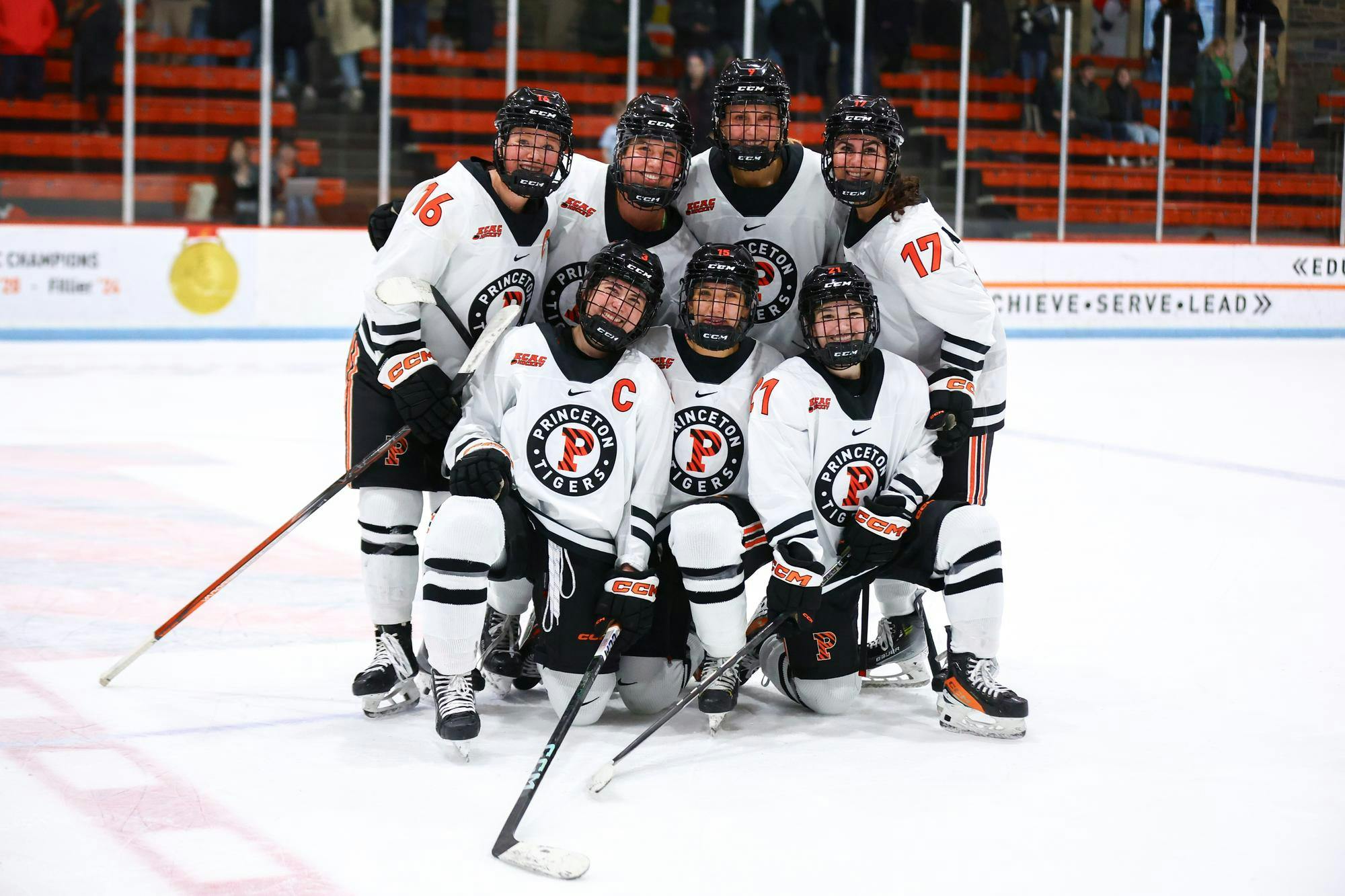 Seven women’s ice hockey players pose on the ice