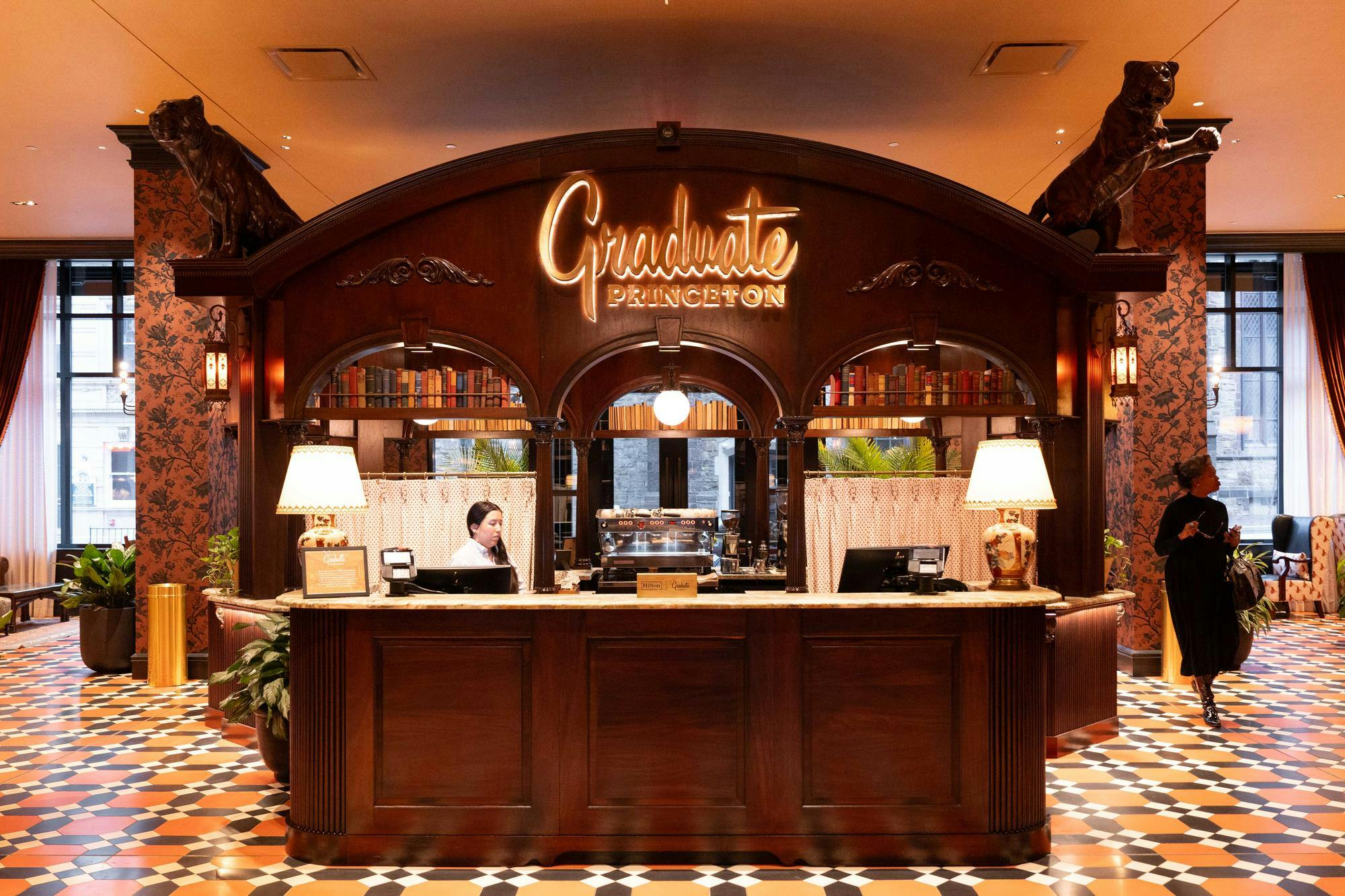 A large mahogany bar with ornate decor set-up in the middle of the lobby.