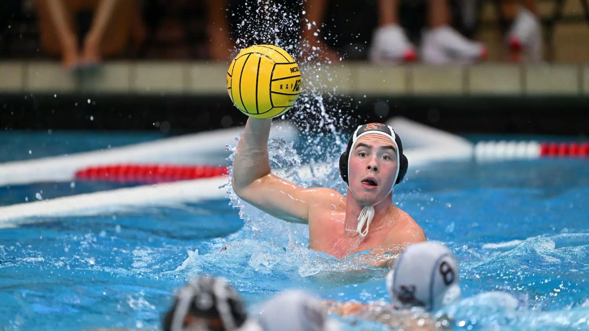 A men’s water polo player winding up for a shot.