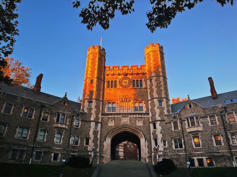 Stone building with towering arch, lit orange by the sunset.