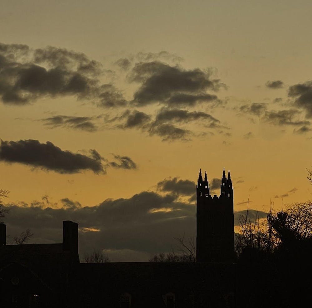 &nbsp;Square photo of silhouette of building with four spires plus lots of clouds in front of a yellow sky.&nbsp;
