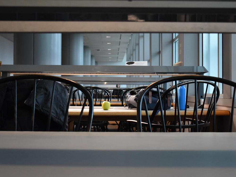 Backpacks, and apple, and a water bottle rest on a table