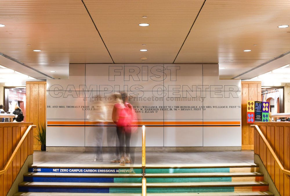 Long exposure photograph of students walking in front of a wall with the words “Frist Campus Center.”