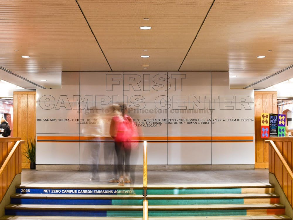 Long exposure photograph of students walking in front of a wall with the words “Frist Campus Center.”