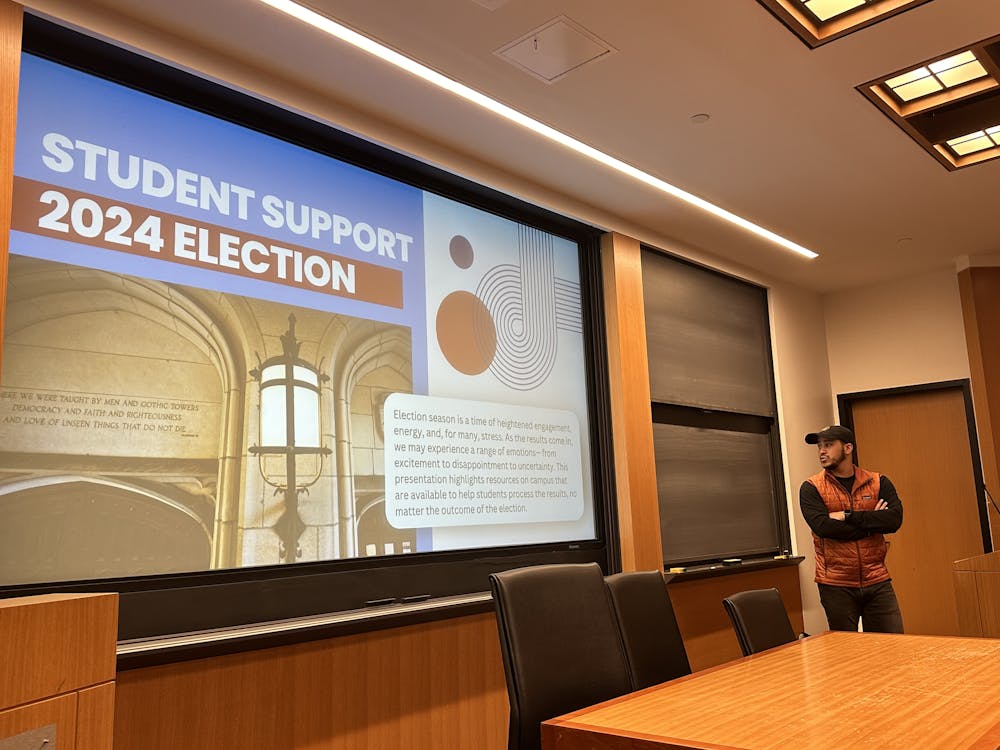 Dean Ian Deas stands to the right of a presentation titled "Student Support 2024 Election"