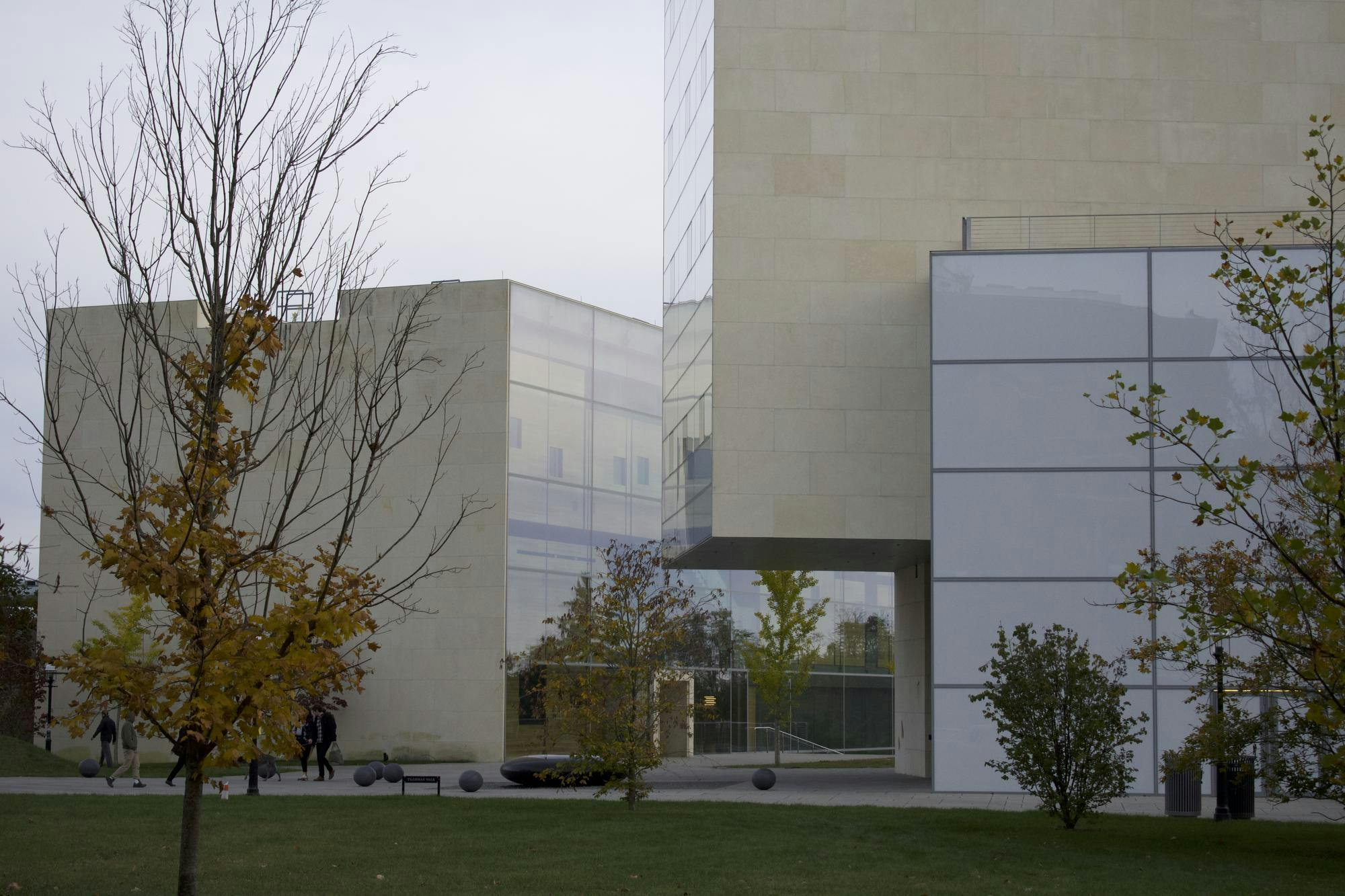 A complex of white, avant-garde buildings with lots of windows sit in a courtyard. 
