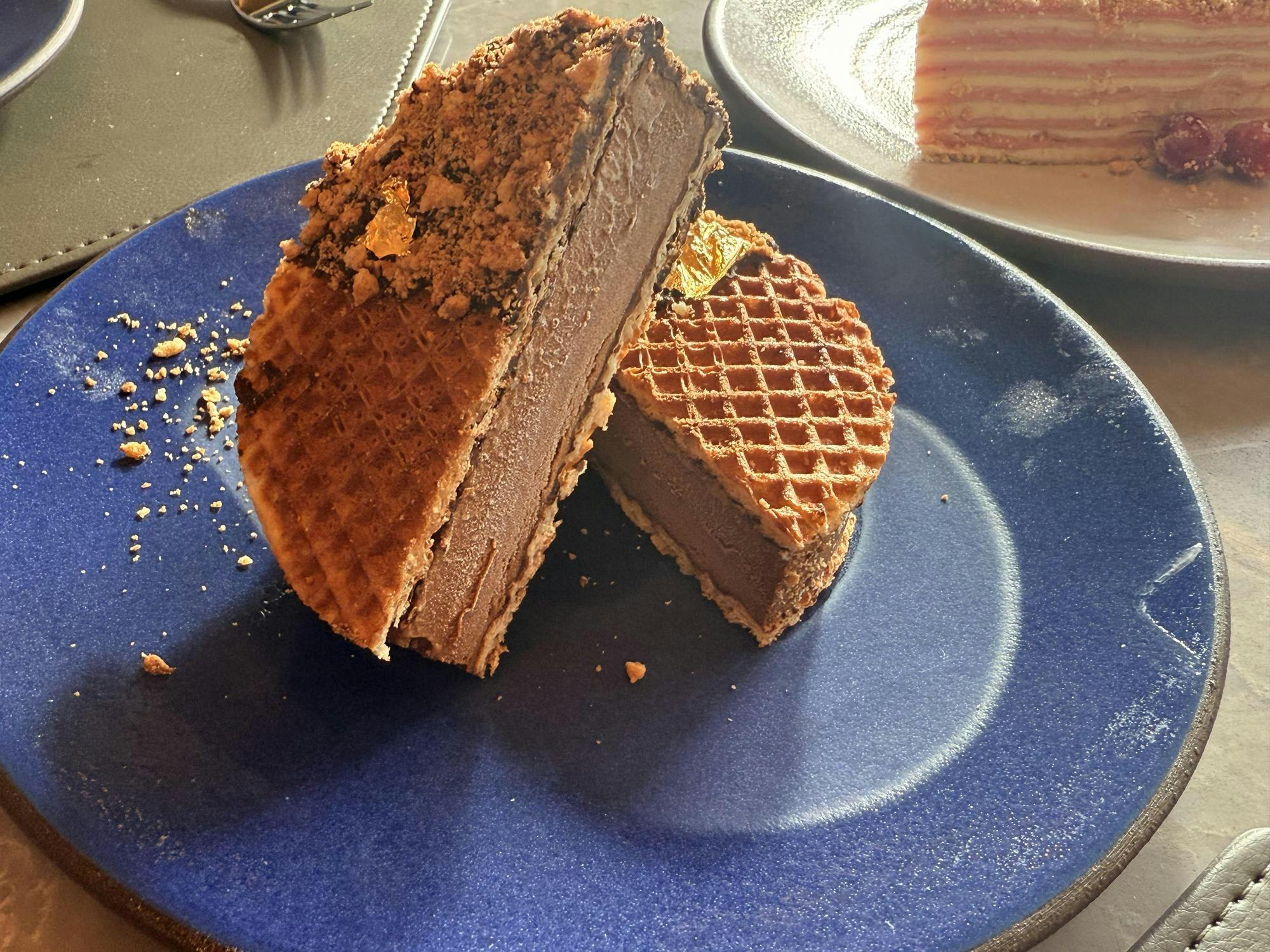 Chocolate ice cream between two waffles. Served on a blue plate.