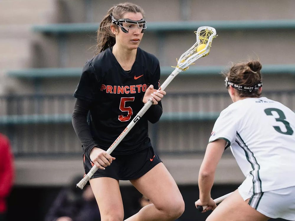 Princeton women's lacrosse player in black jersey makes a move against a defender in white.