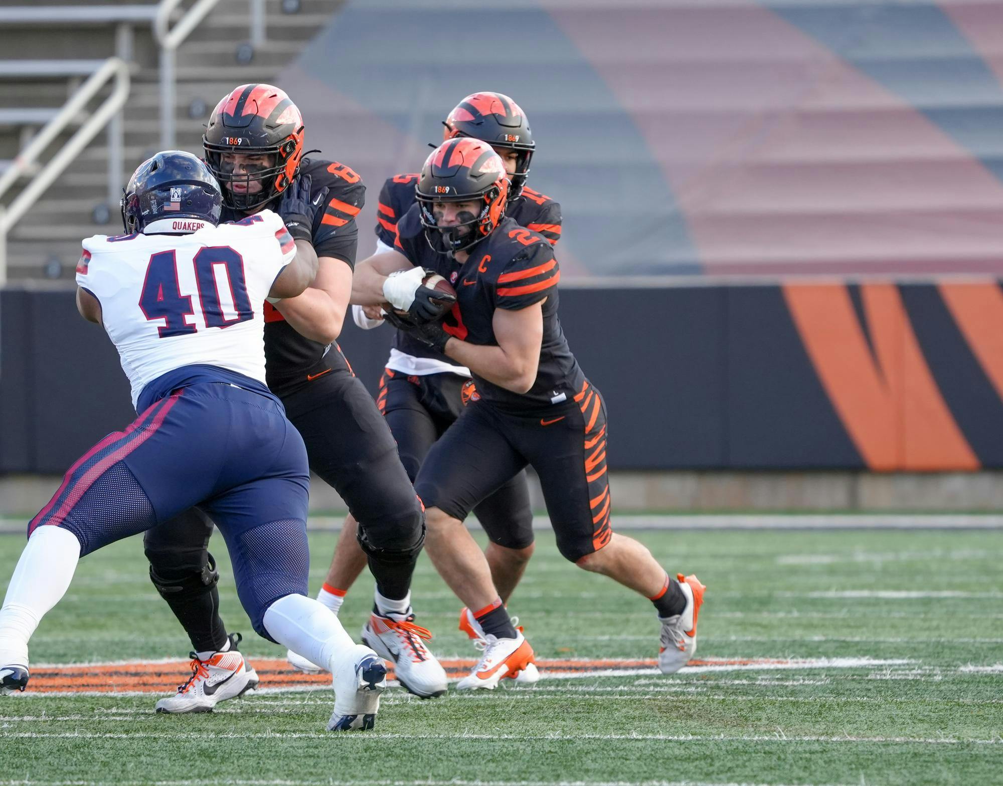Man running with a football on a field.