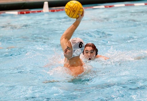 man in water polo headgear gathers up to shoot 
