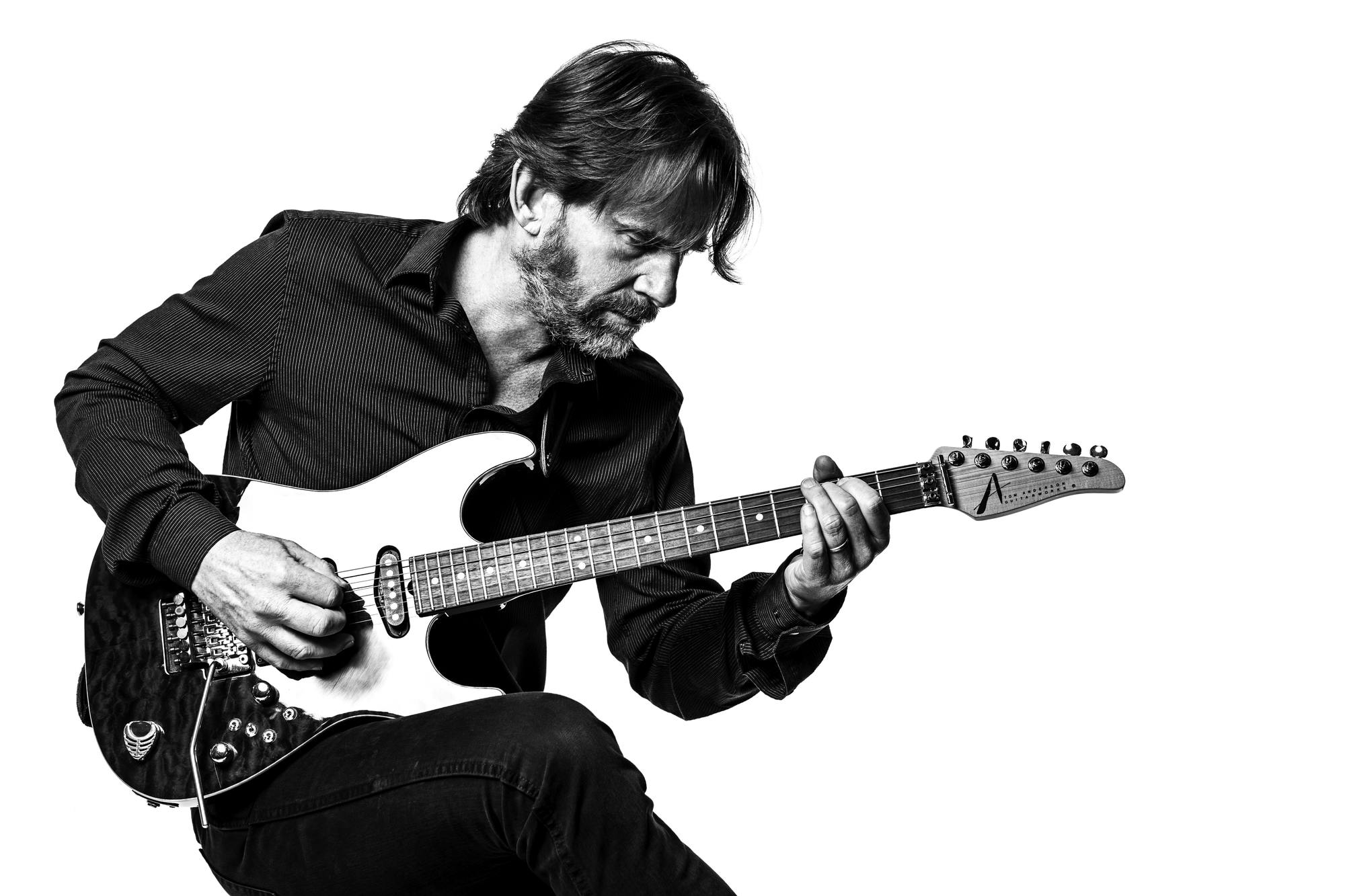 Mackey poses with a guitar. 