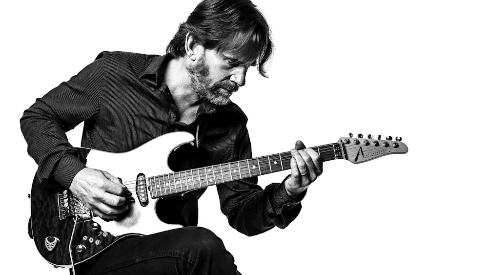 Mackey poses with a guitar.