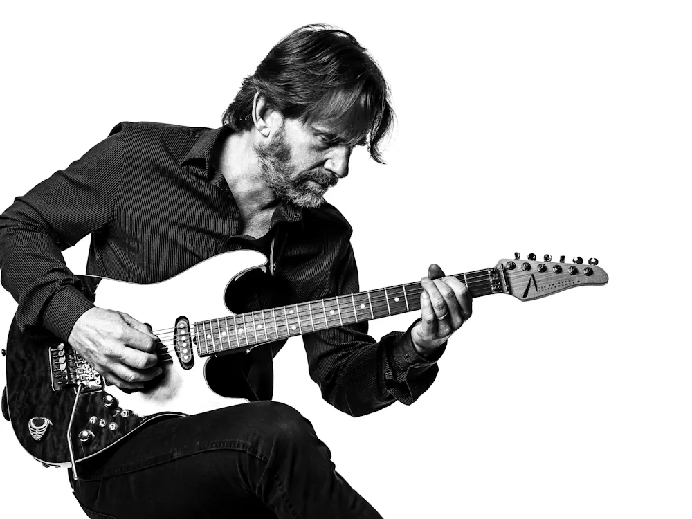 Mackey poses with a guitar.