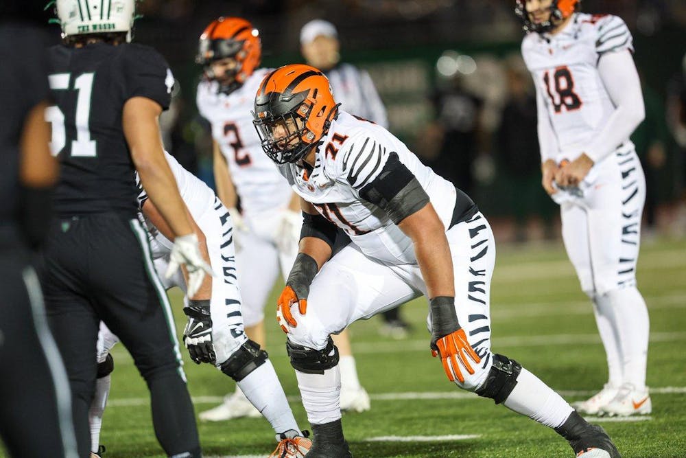 Man crouching on football field.