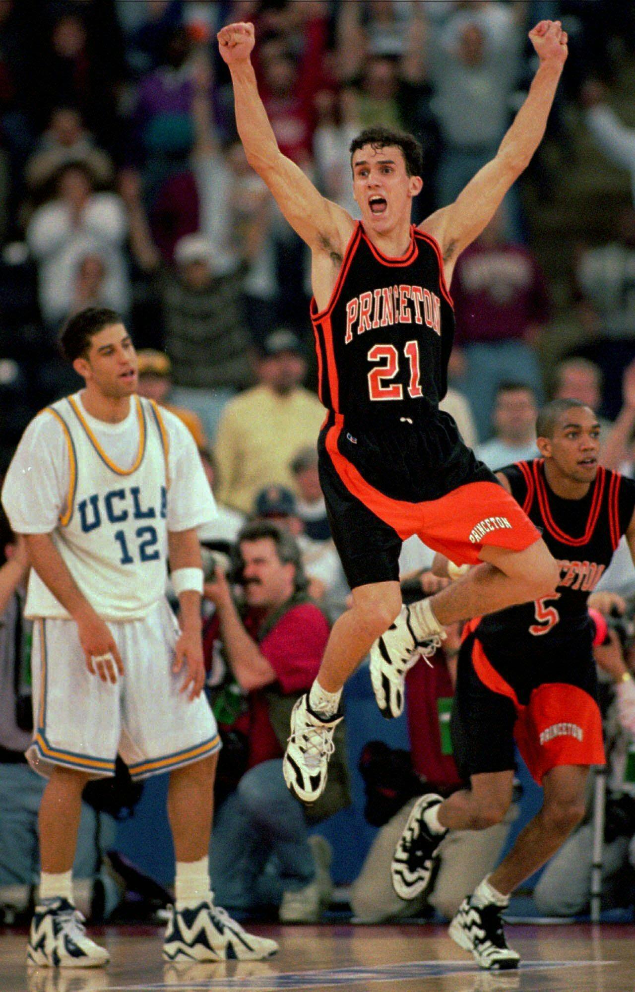  Photograph of Princeton basketball player, Mitch Henderson ’98, in his uniform, jumping in the air with a UCLA basketball player and teammate Sydney Johnson ’97 behind him.