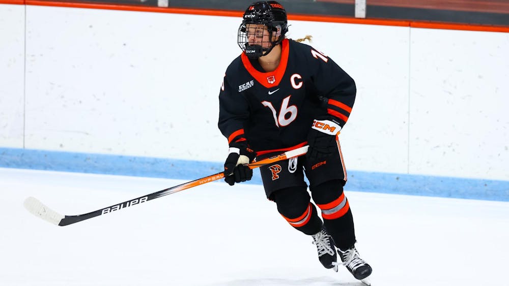 Woman wearing orange and black hockey attire.