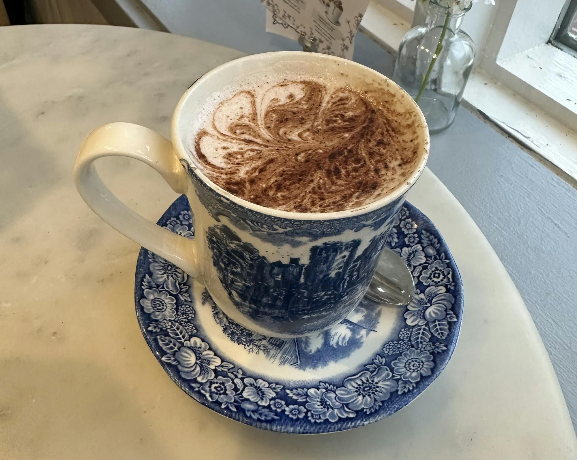 Blue porcelain china cup filled with swirled hot chocolate.