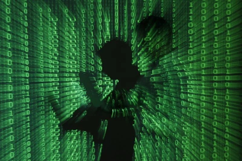 Silhouette of men with computers in a cryptic background.