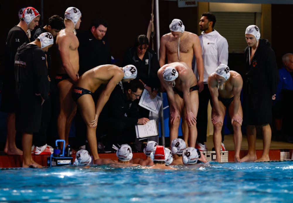 A group of men in a huddle looking at a man giving them directions on a piece of paper.