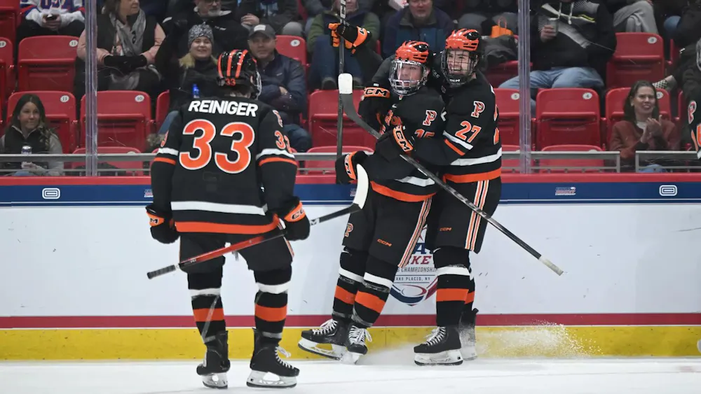 Hockey players hug on ice.