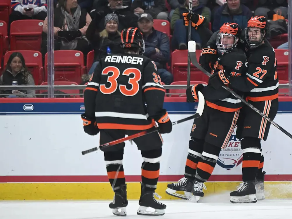 Hockey players hug on ice.