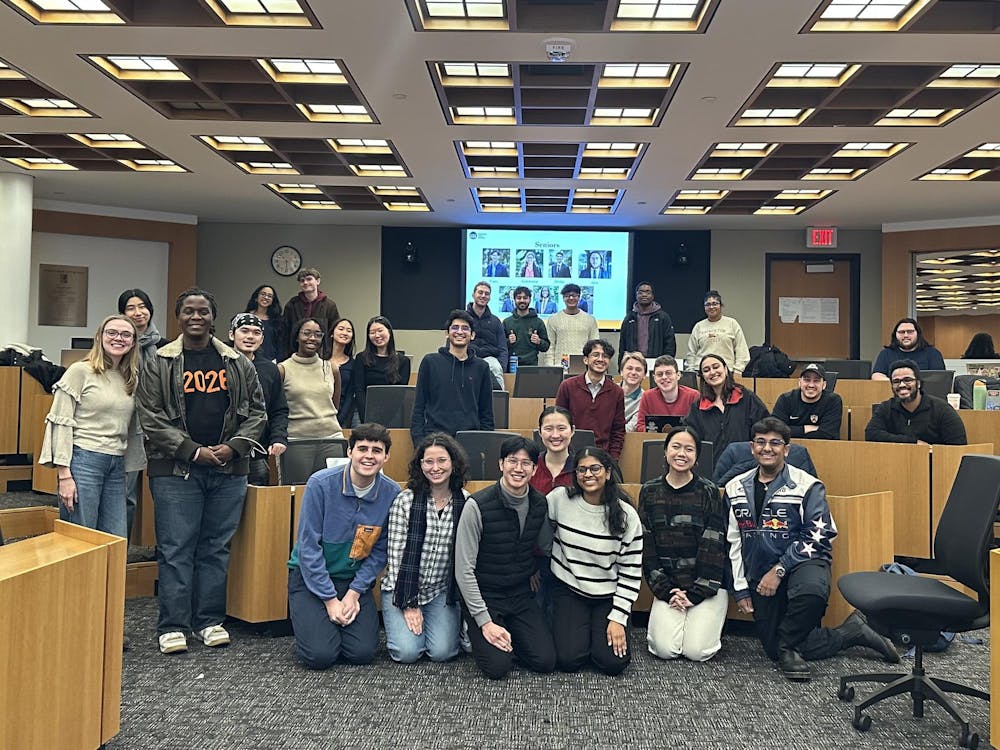 The members of the 2025 Undergraduate Student Government standing happily around in Robertson Hall following their last meeting of the semester.