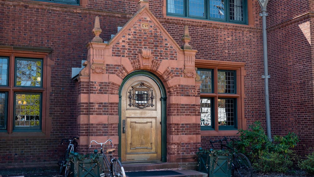 A red brick building with a gold and green front door.
