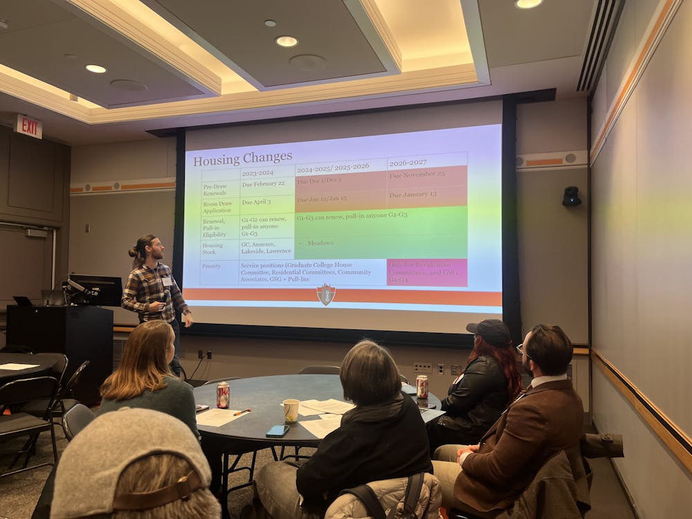 A man presents a table of housing changes on a projector.