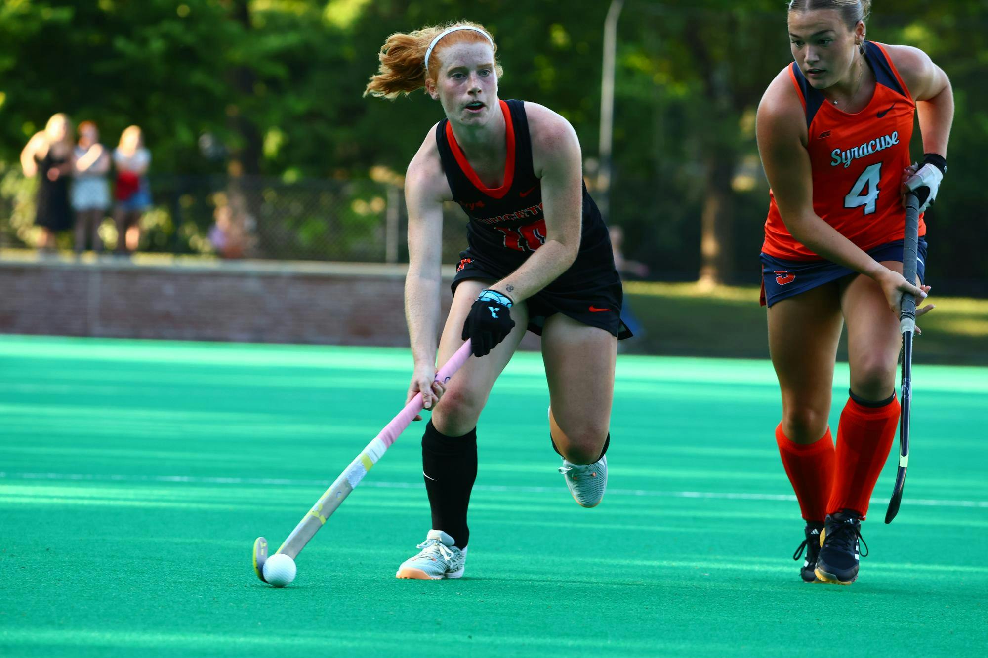 Field hockey players running.