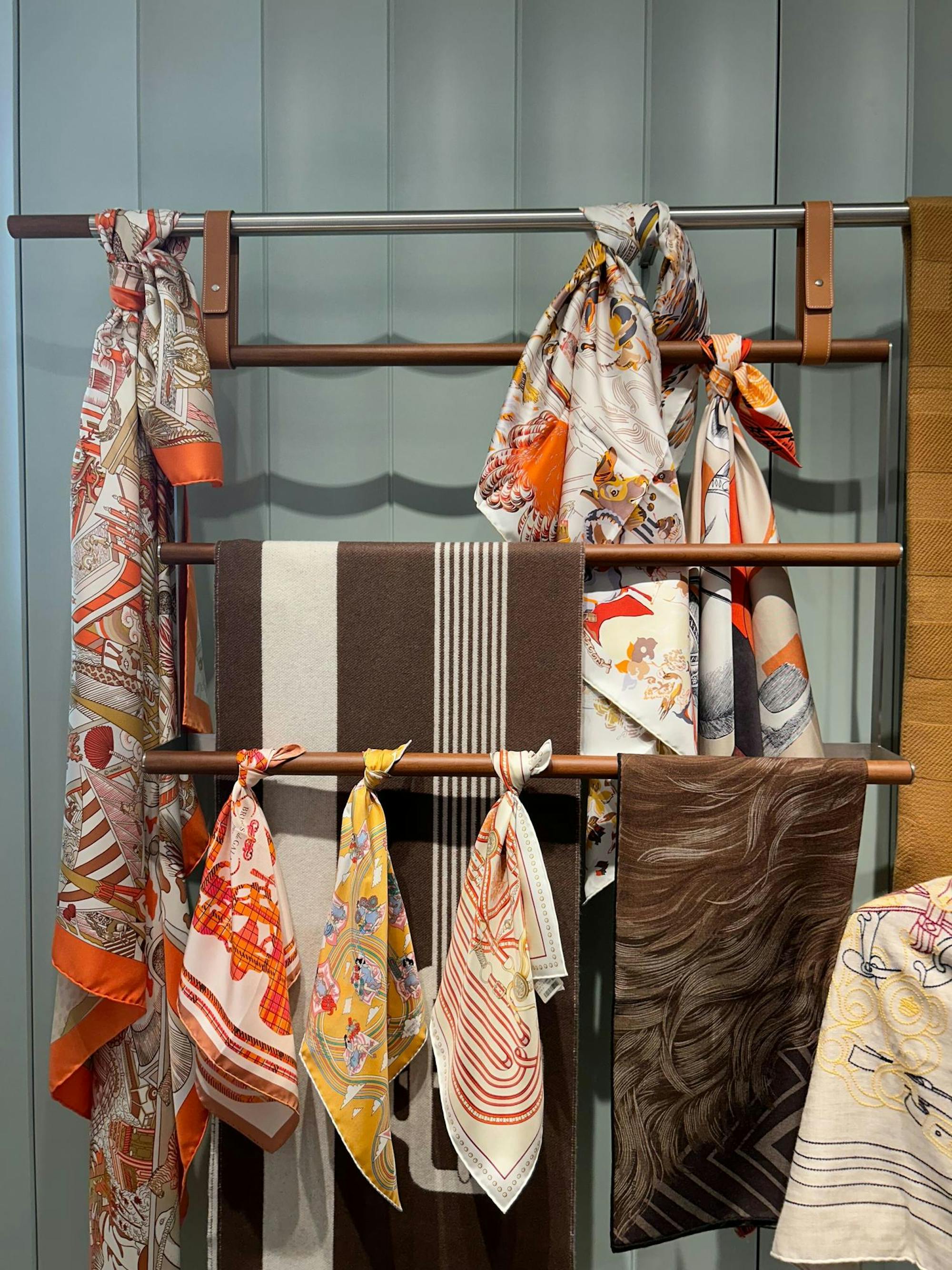 Array of scarves with elaborate designs and a color scheme of brown, orange, and cream.