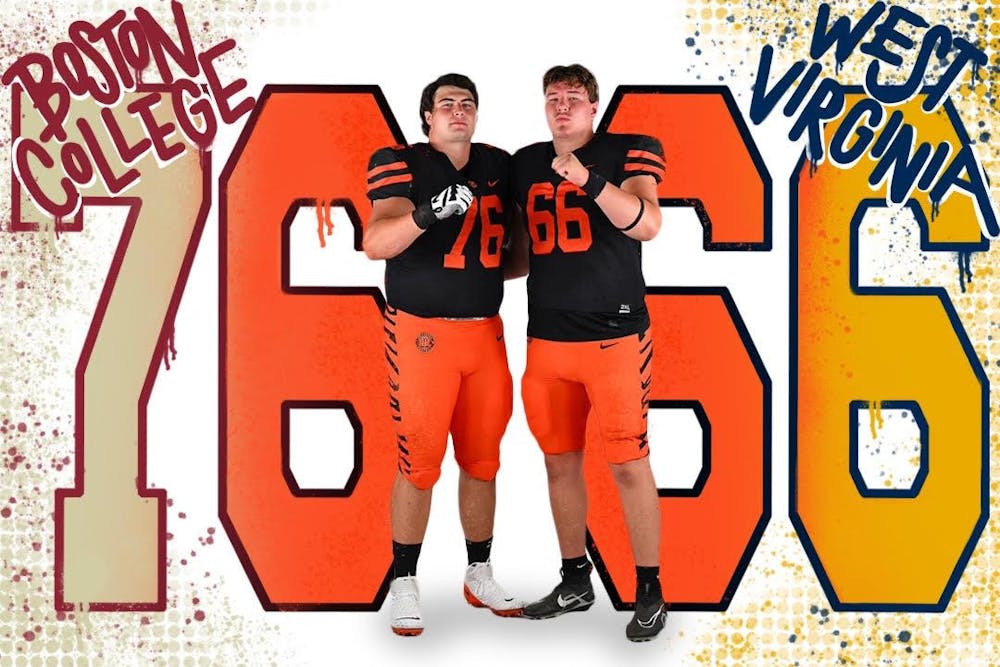 Two football players wearing black jerseys with orange numbers and orange pants stand arm-in-arm with their firsts pumped. To the left of the players is a large 76 and the words Boston College, and to the right is a large 66 with the words West Virginia.