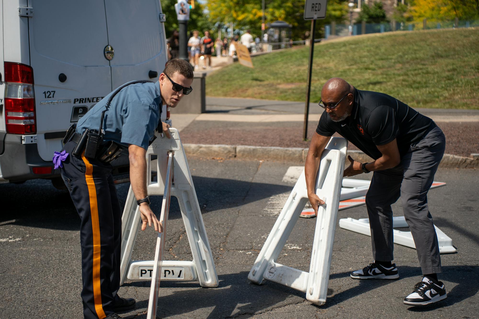 Two officers left a white barricade at a crosswalk.