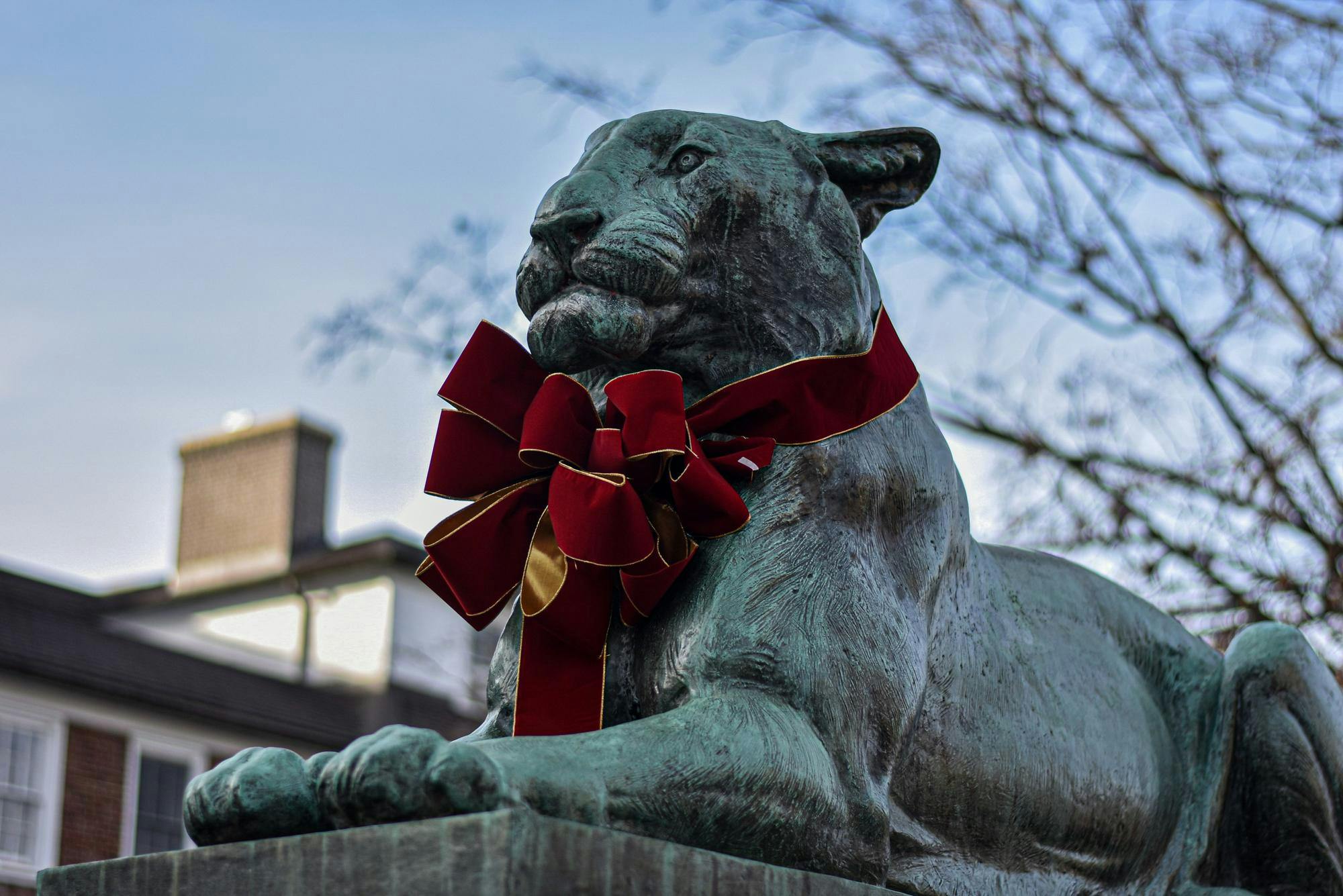 A blue tiger sculpture has a red bow on its neck.