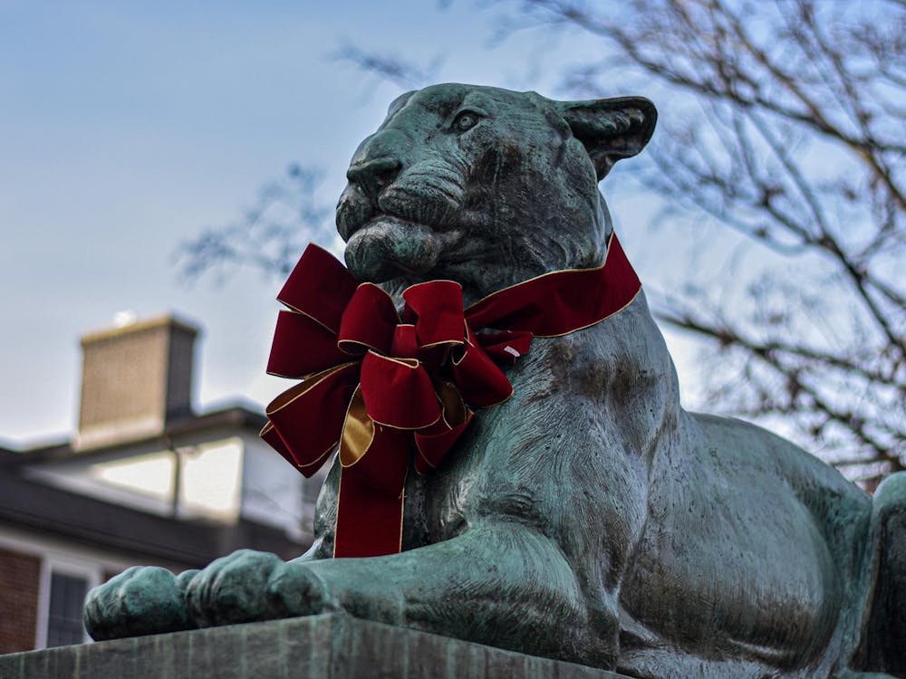 A blue tiger sculpture has a red bow on its neck.
