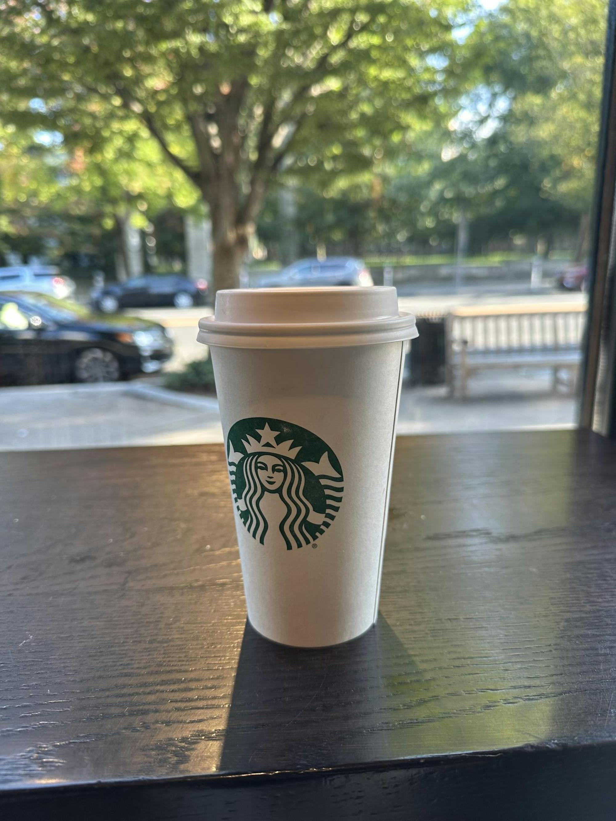 A white cup with a green mermaid logo.