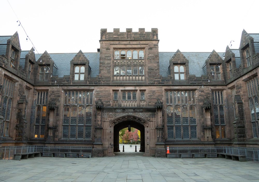 An old Gothic architectural hall surrounding a courtyard with string lights.