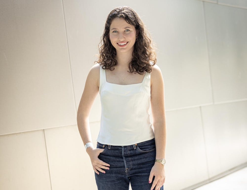 A girl in a white shirt smiles at the camera. 