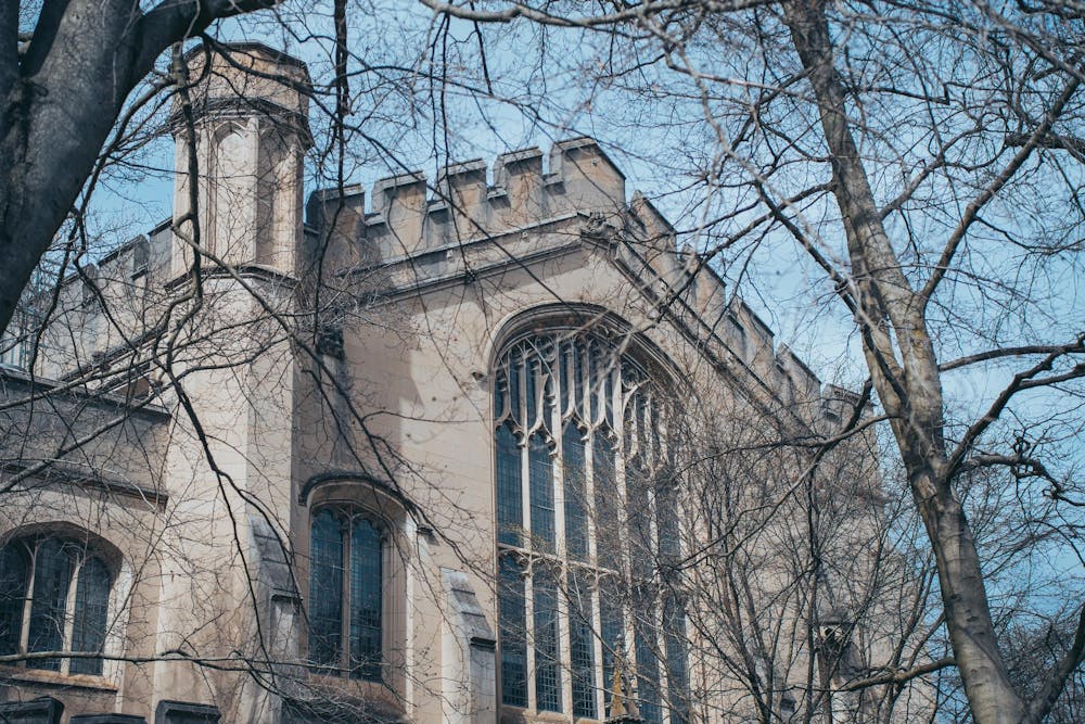 A Gothic building through bare trees. 