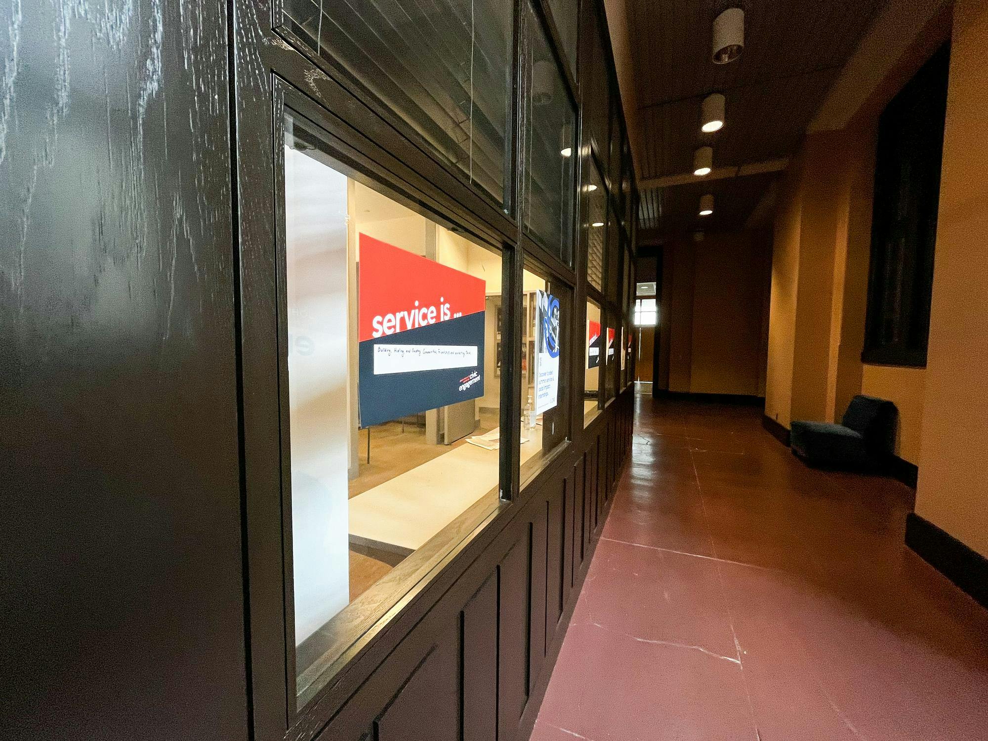 A red and white sign that says "service" is hung on a window into an interior room in Frist. 