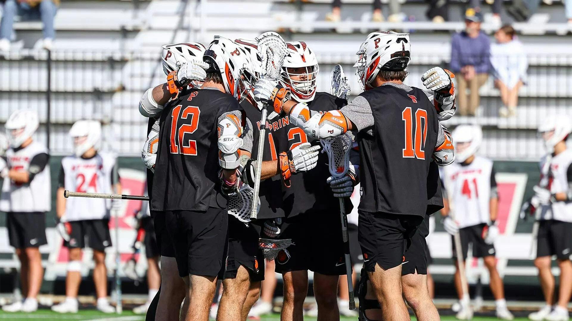 Group of Princeton Men's Lacrosse players circling up together.