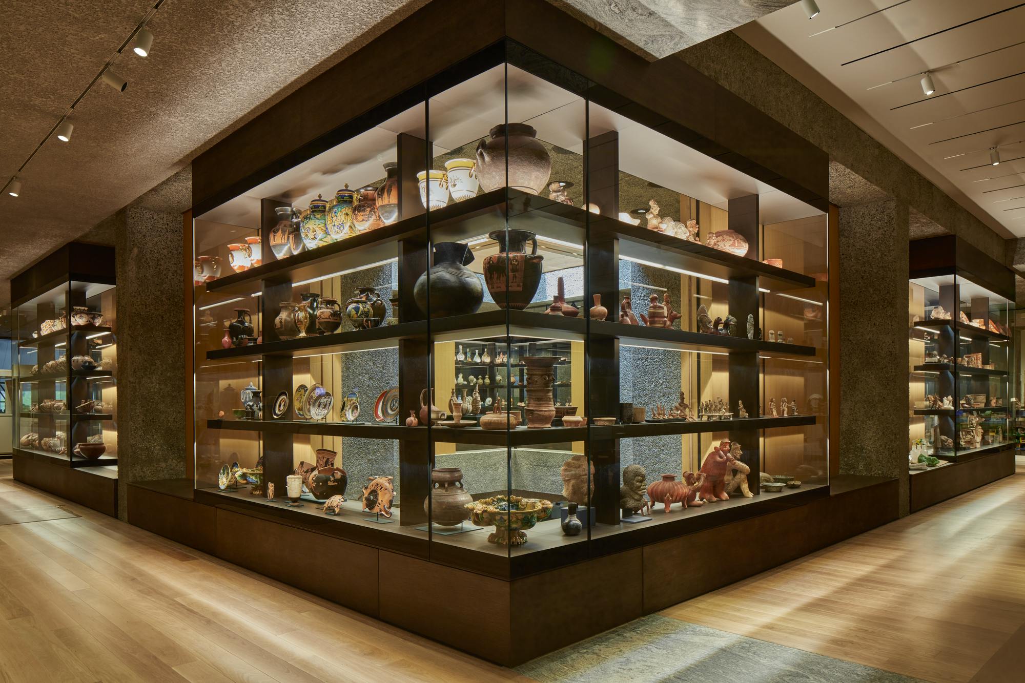 Integrated glass cases holding many vases, bowls, and other objects on shelves.
