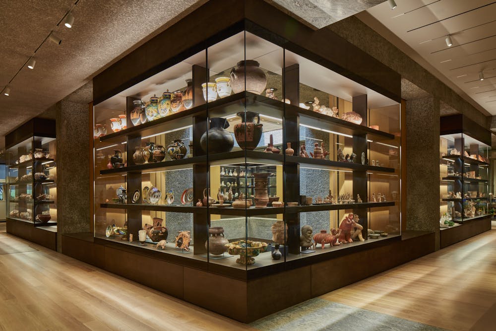 Integrated glass cases holding many vases, bowls, and other objects on shelves.