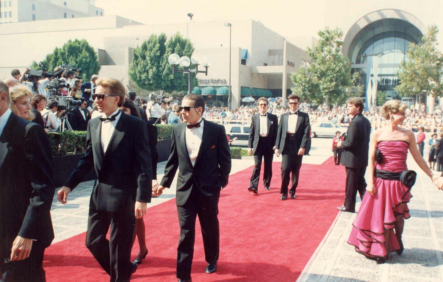 Celebrities walking across a red carpet.