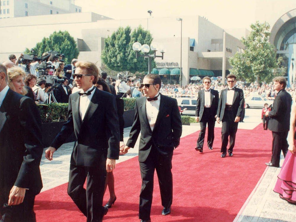 Celebrities walking across a red carpet.
